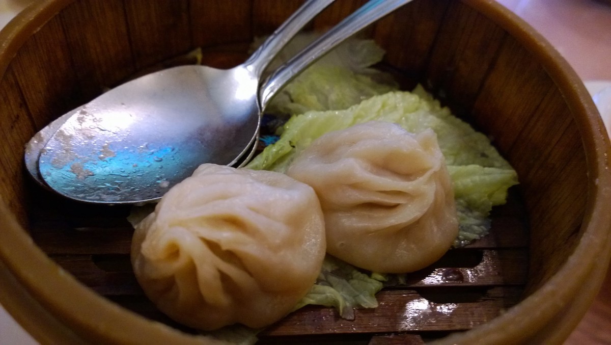 Close up of two soup dumplings in a bamboo steamer basket. Xiao long bao is a great thing to eat in San Francisco