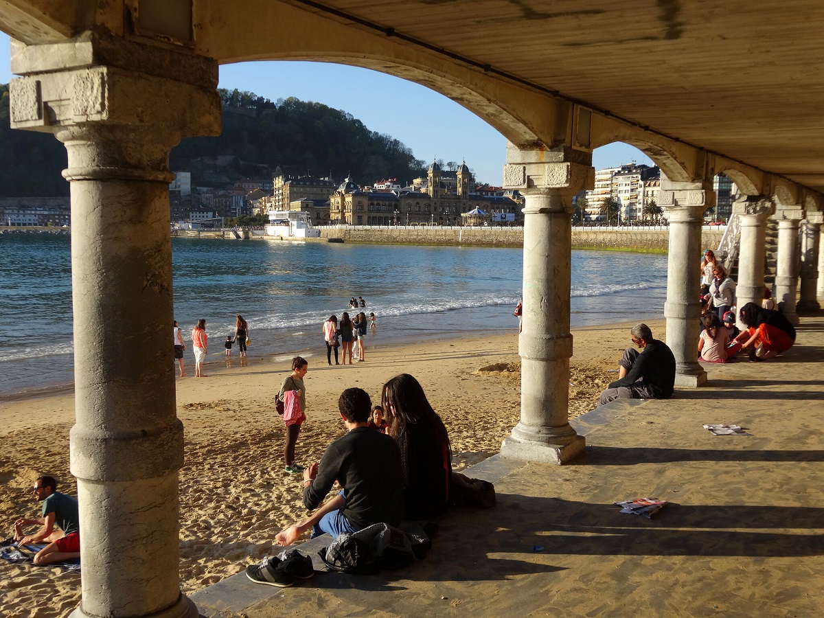 Couple on La Concha beach in San Sebastian look out onto the water