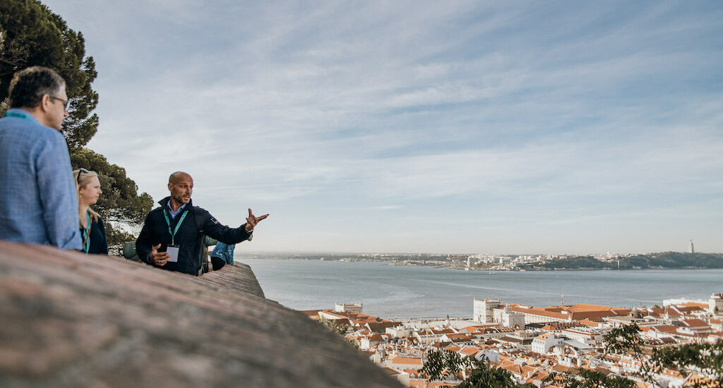 tour guide pointing out at the Tagus River from the edge of Lisbon's water front