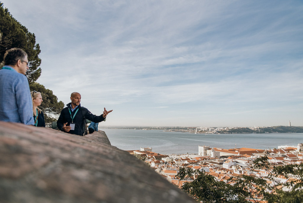 tour guide pointing out at the Tagus River from the edge of Lisbon's water front