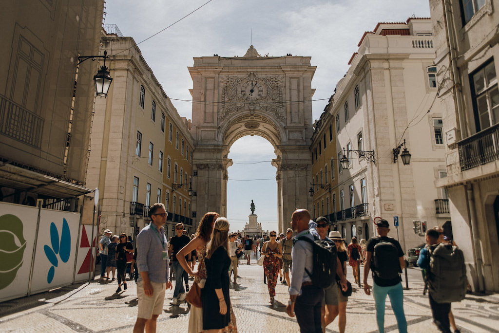 Arco da Rua Augusta in Lisbon in the background with a tour group in the foreground