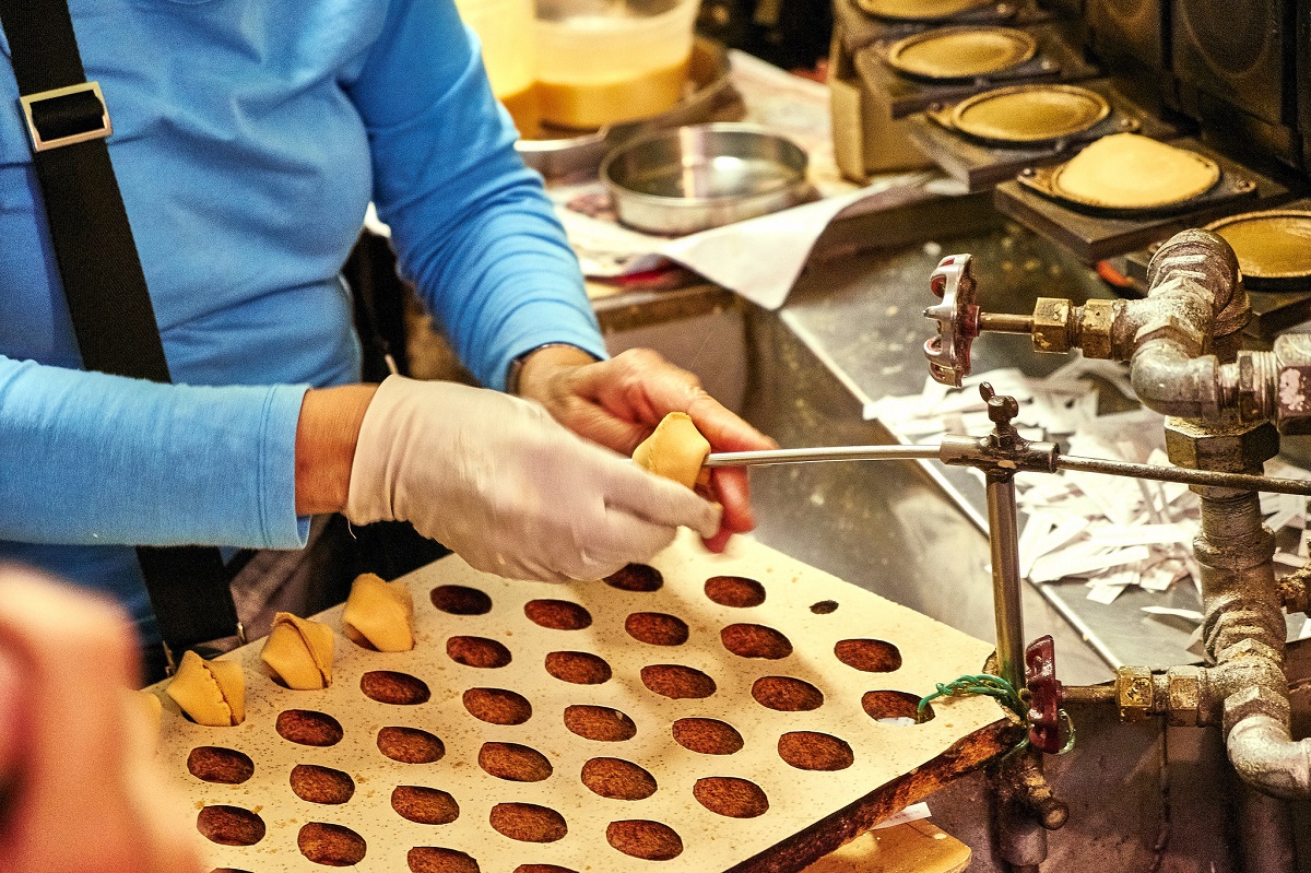 Woman folding fortune cookies at the San Francisco Golden Gate Fortune cookie factory