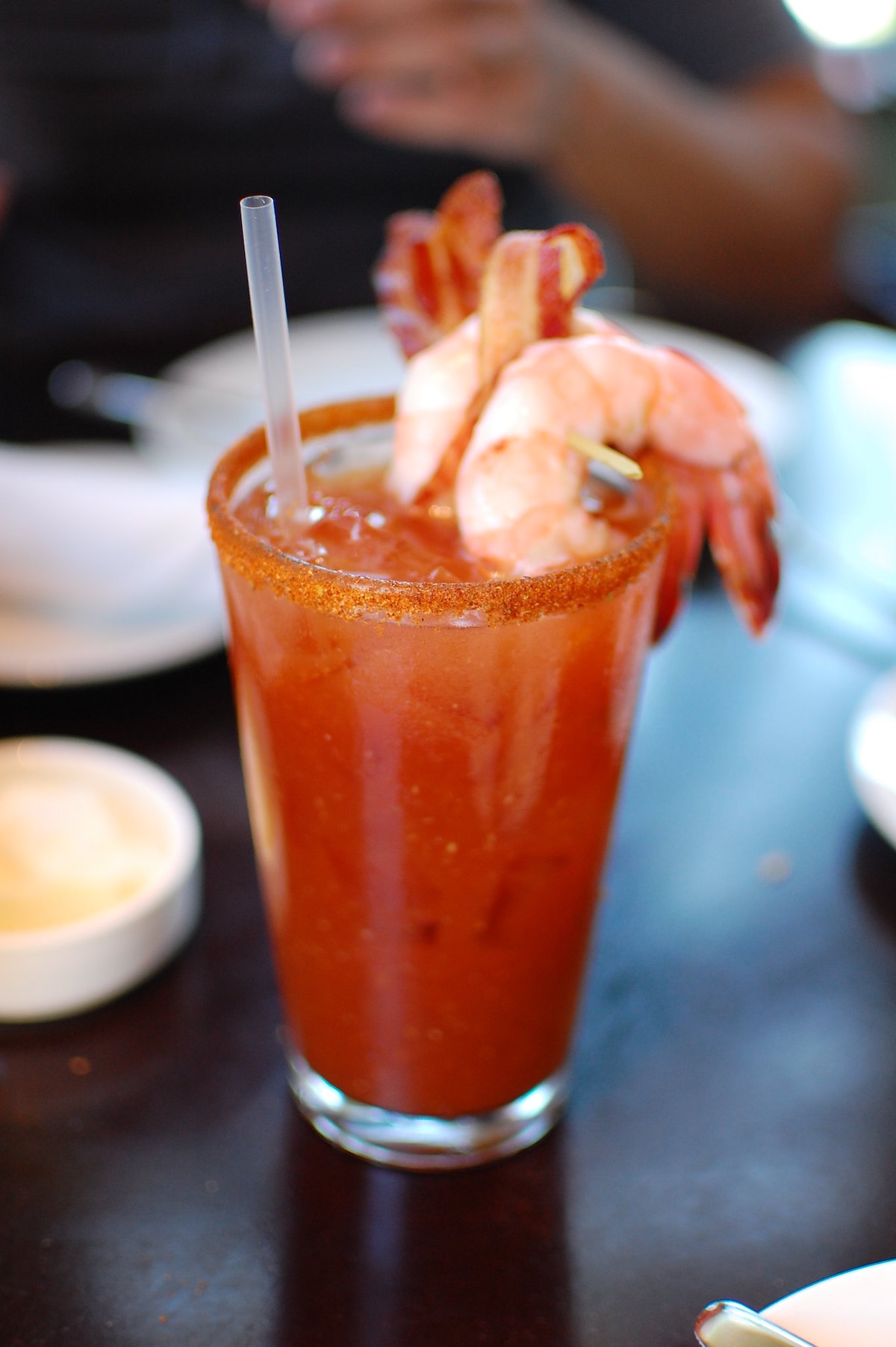 Close up of a bloody mary cocktail with a salted trim and two jumbo shrimp garnish