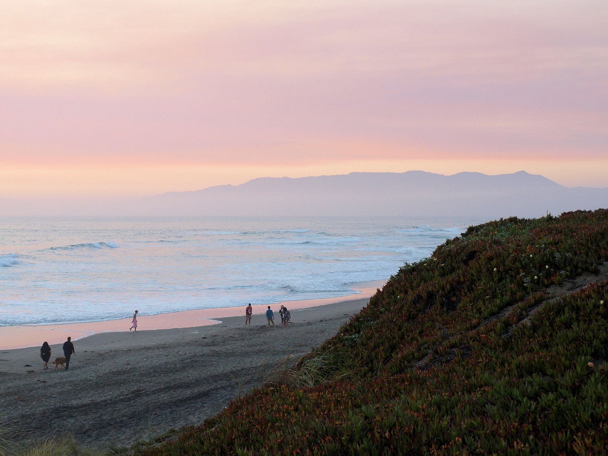 Ocean beach in the San Francisco bay area at dusk with mountains and water