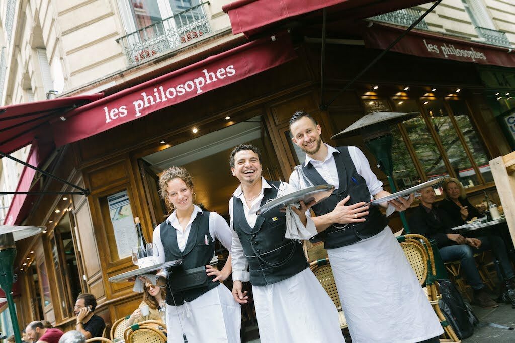Les Philosophes waiters standing outside of the Paris bistro