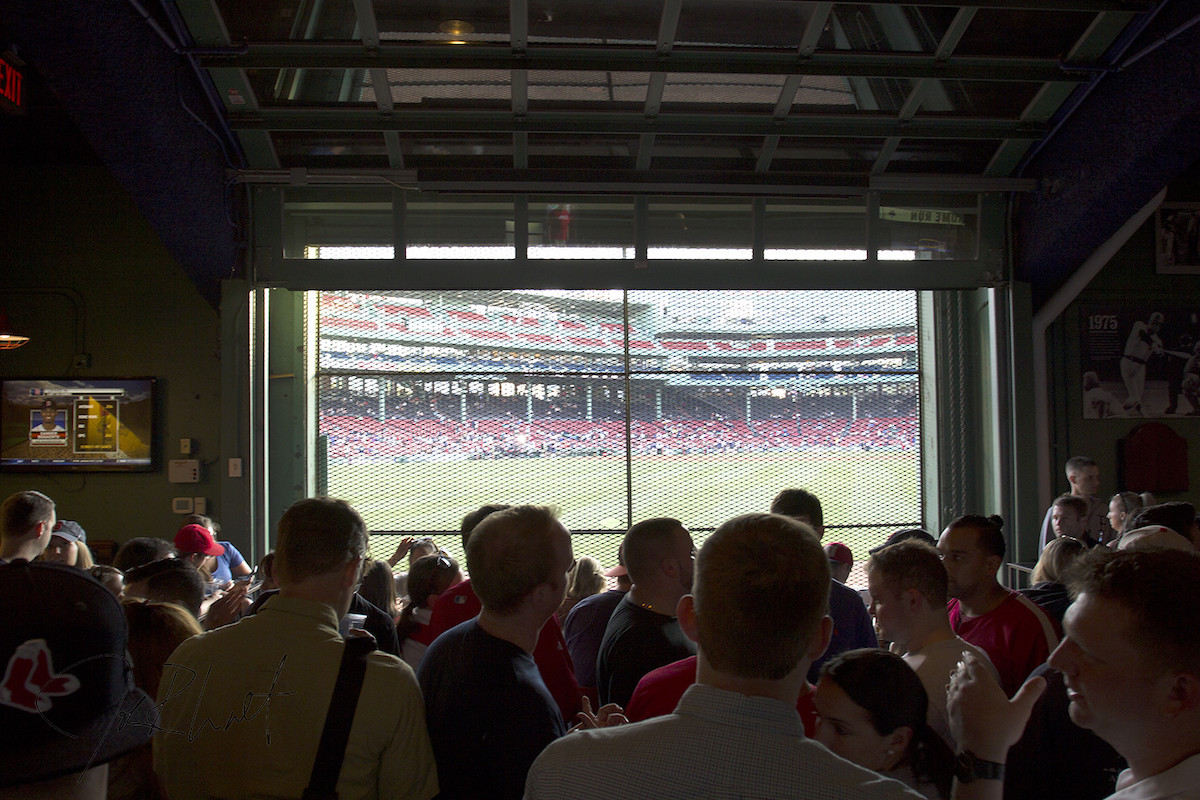 A view of a Boston Red Sox baseball game through a large window at Bleacher Bar, a Boston hidden gem
