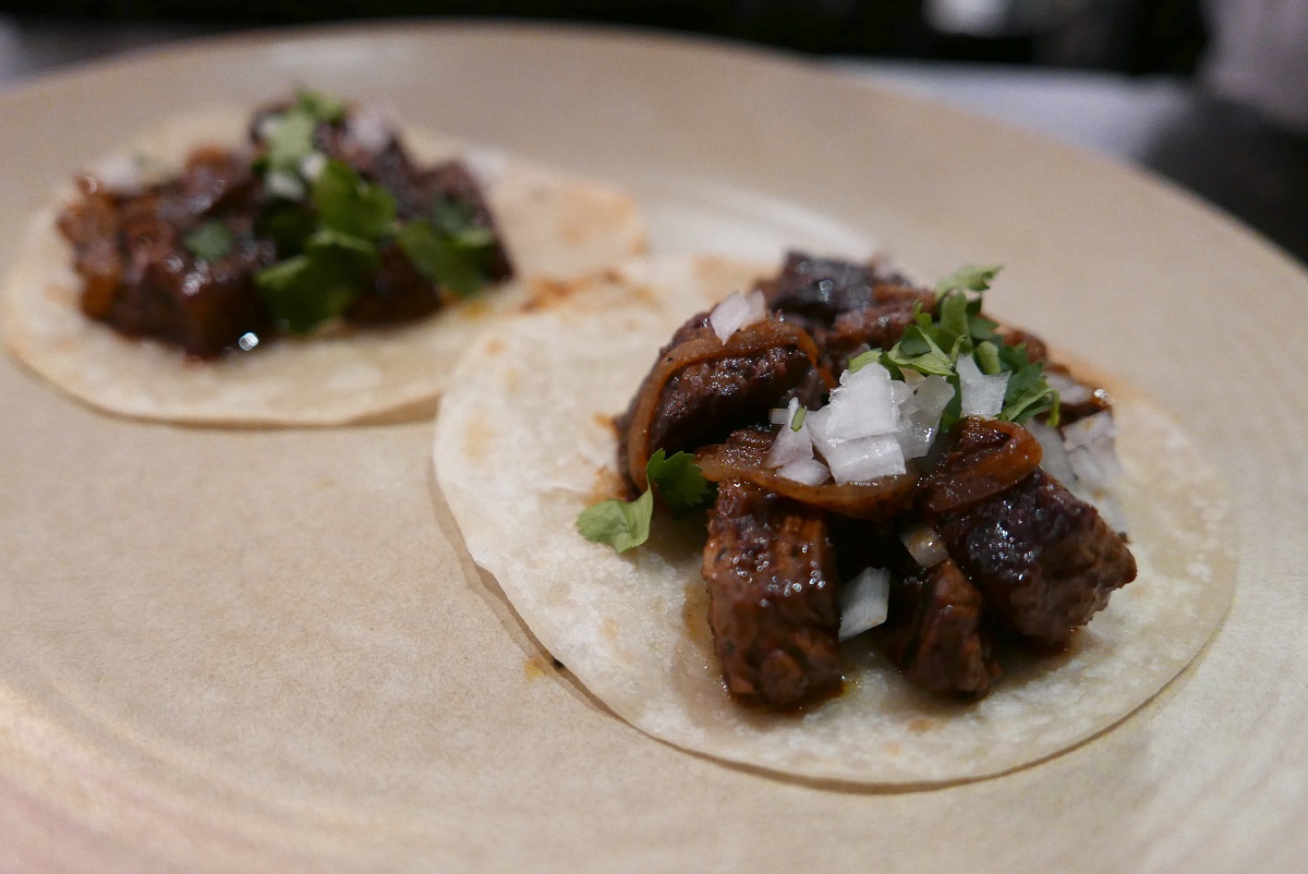 Two small tacos with shirt steak and chopped onions