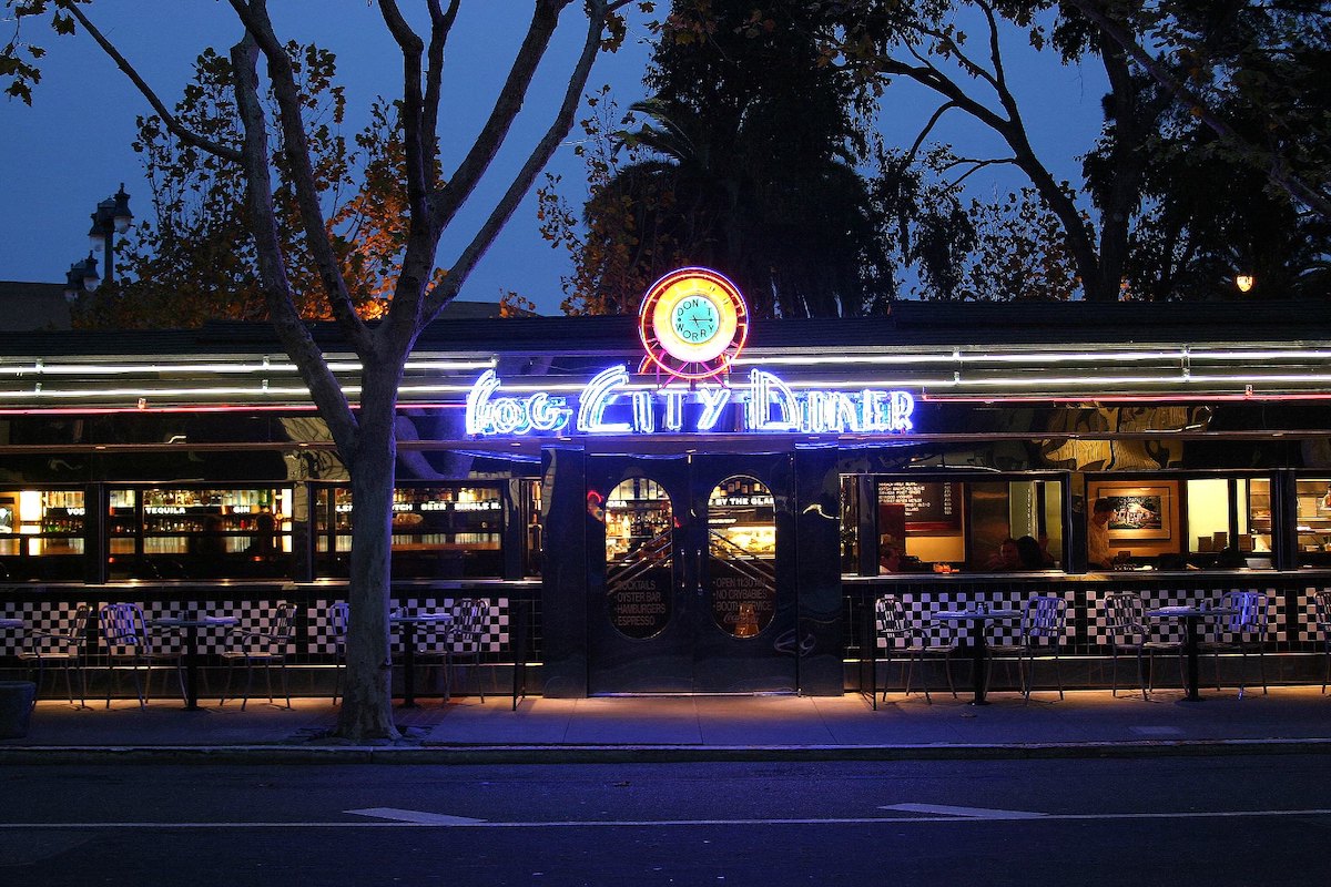 exterior shot of fog city diner in the evening. the Sky is dark and the bright neon sign reads "Fog City Diner"