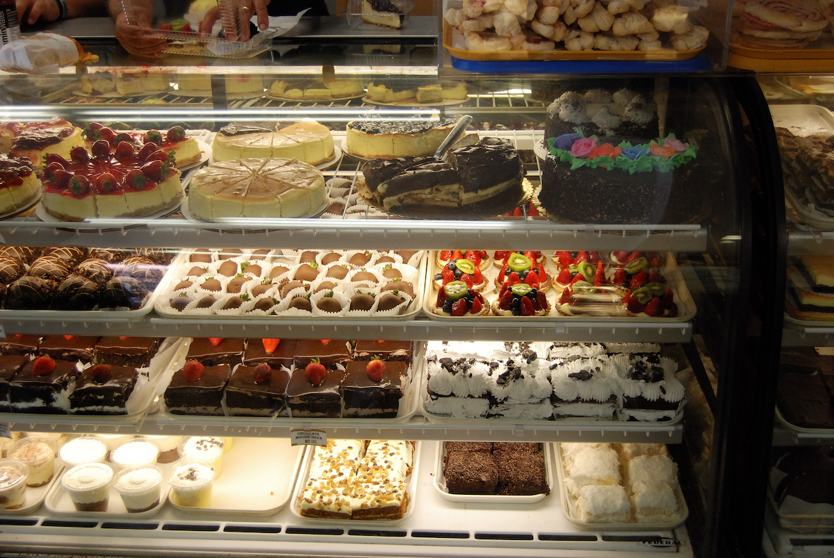a pastry case loaded with cakes, pies, chessecakes, and more at Bova's Bakery in Boston