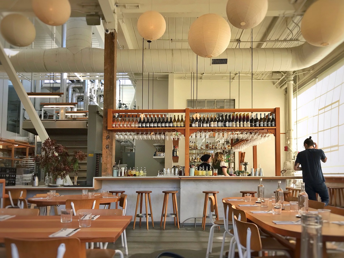 Tartine Manufactory restaurant with open kitchen, bar, tables, and chairs in San Francisco
