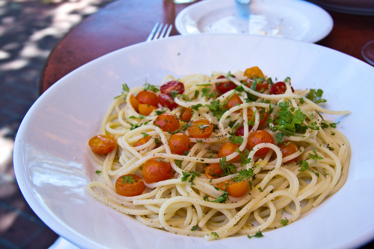 close up of a plate of spaghetti with fresh tomatoes