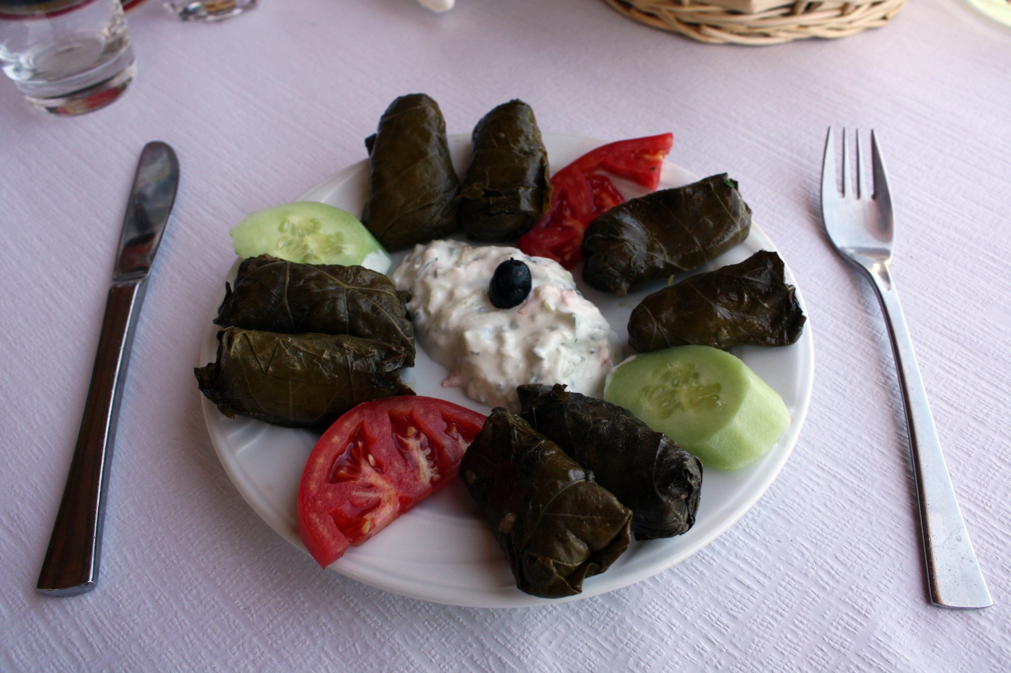 grape leaves on a plate with tomato and cucumber
