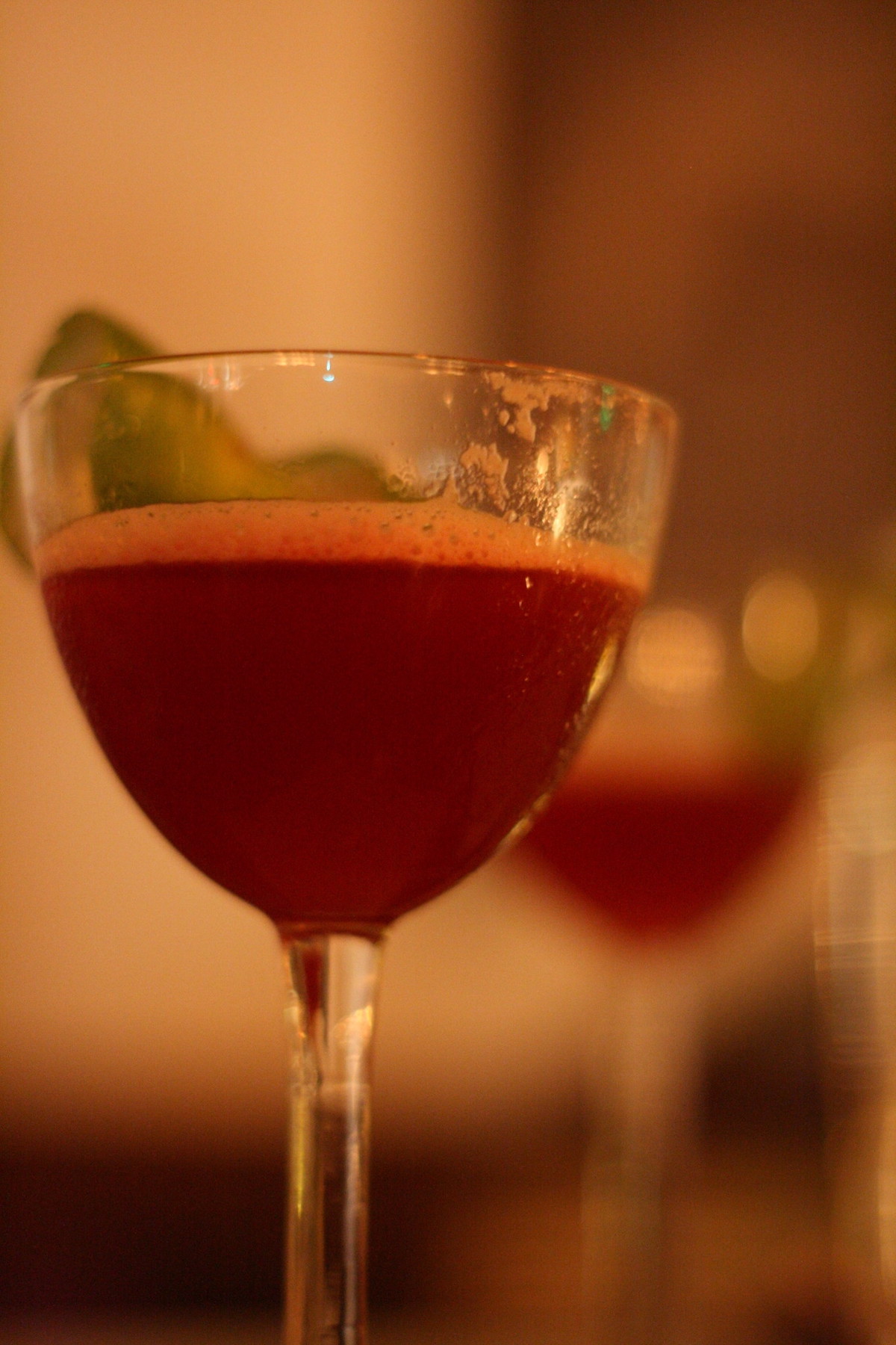 extreme close up of a red cocktail in a small cocktail glass