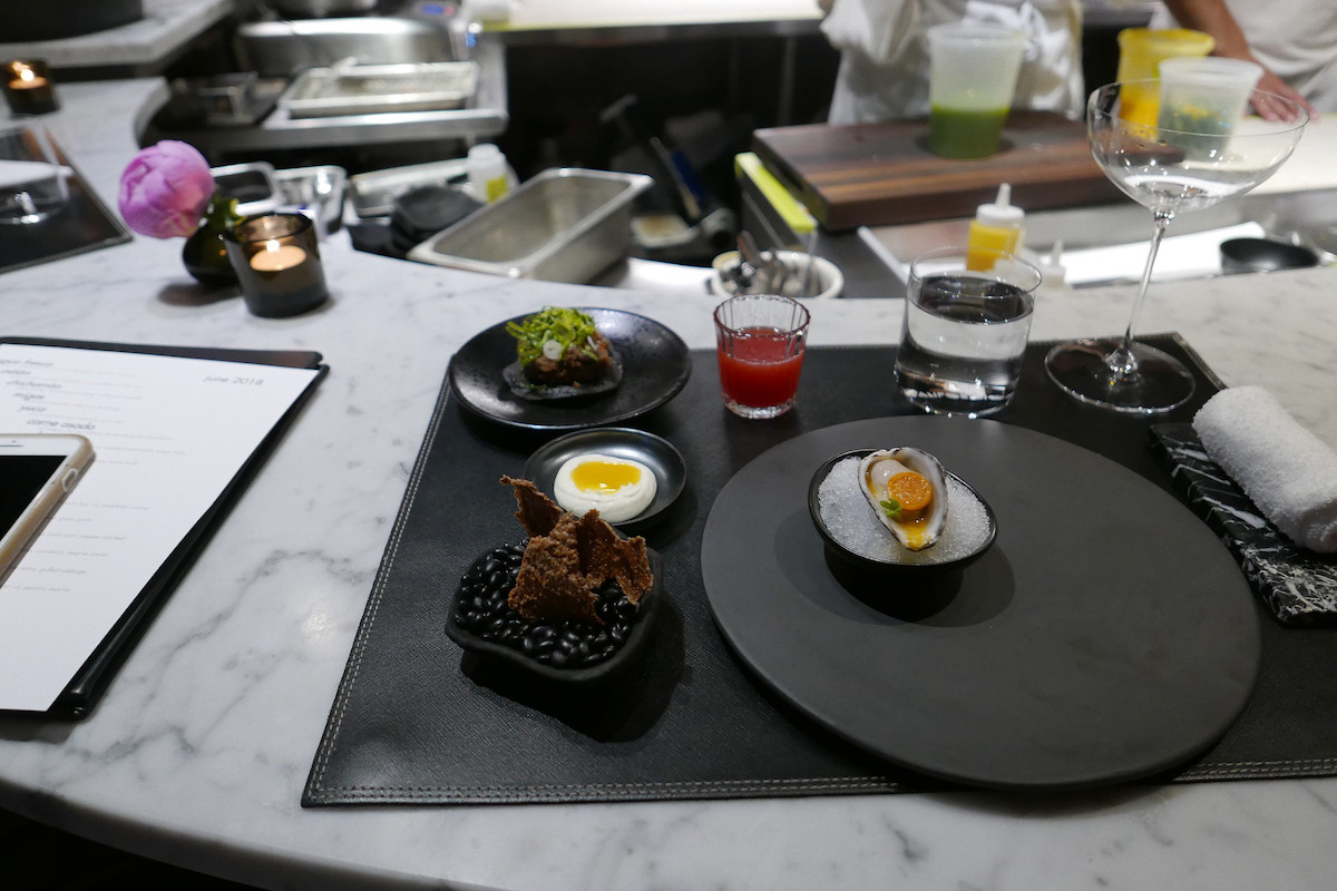 a selection of fine dining starters on black serving dishes at a michelin star restaurat