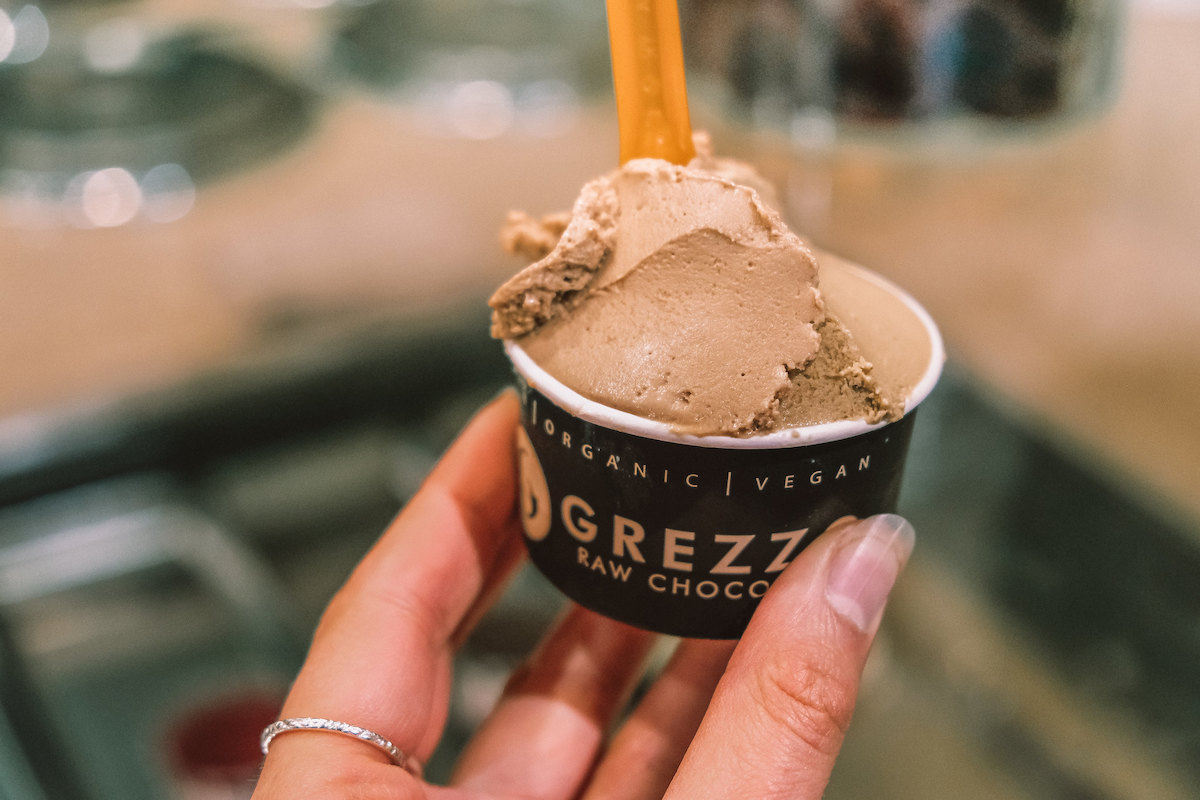 Close up of someone holding a small cup of vegan chocolate gelato