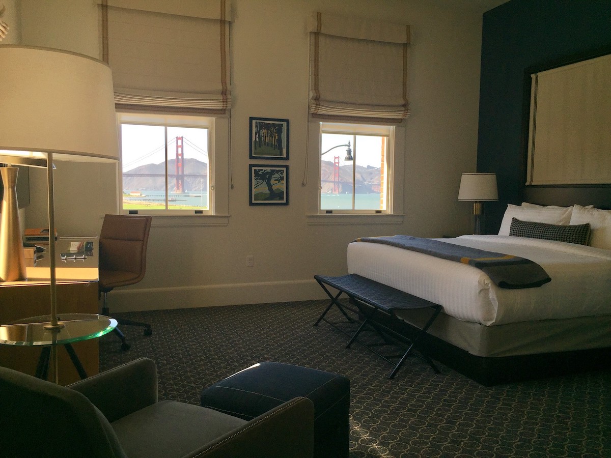 Interior of a hotel room with a view of the Golden Gate Bridge through the windows 