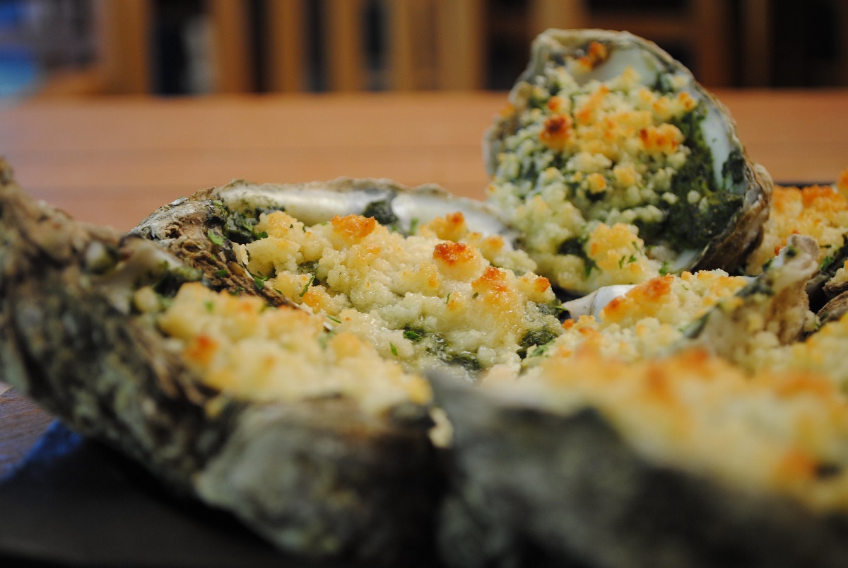 A plate of oysters Rockefeller with toppings
