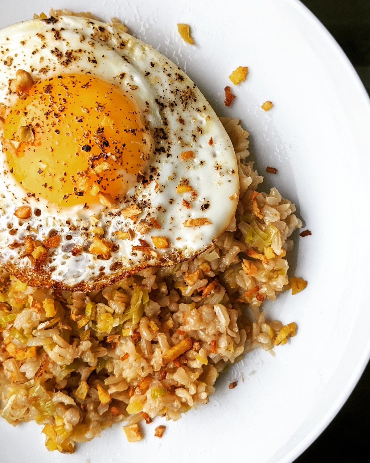 Close up of a white plate with ginger fried rice and a fried egg on top. The recipe comes from Chef Jean-Georges of abcV, a vegetarian restaurant in NYC