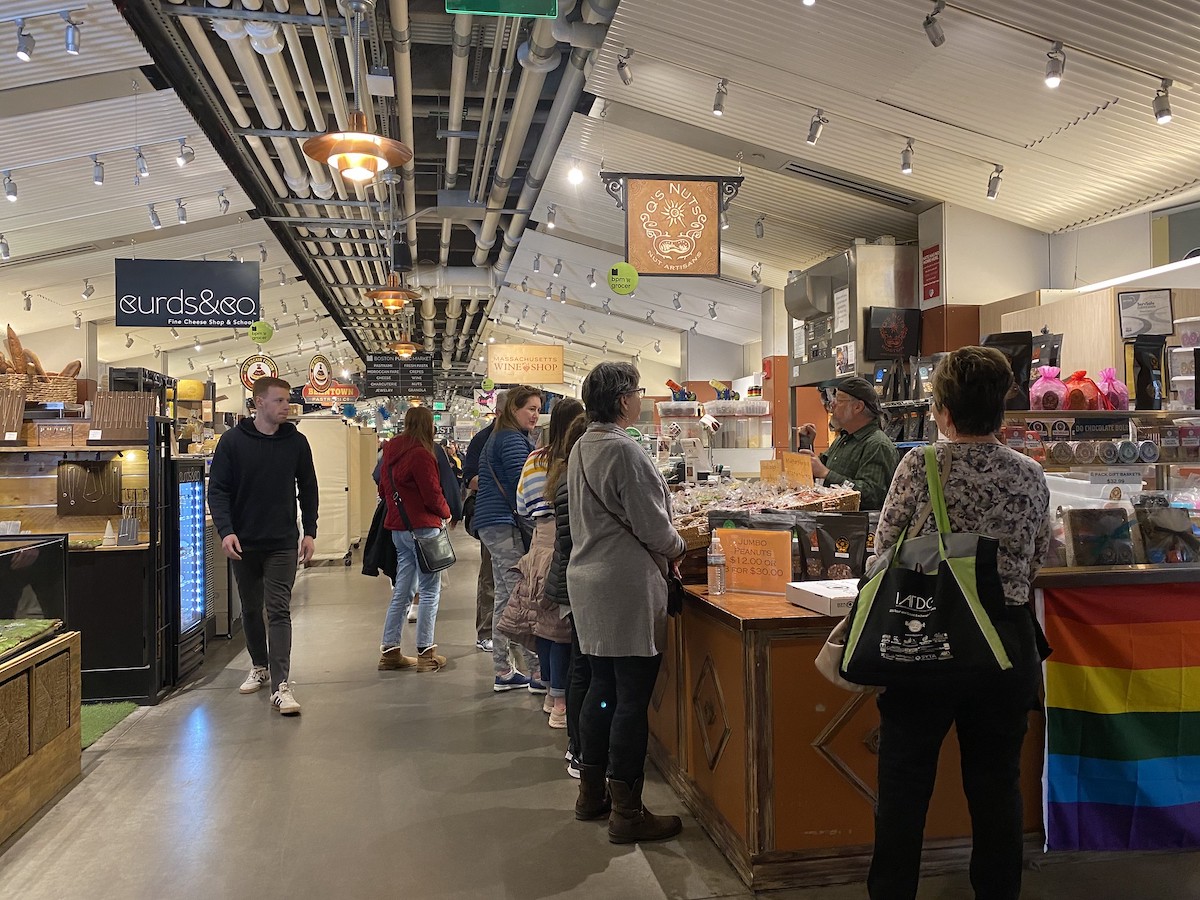 People wait in line at a vendor's stall at Boston Public Market, a great spot for street food in Boston