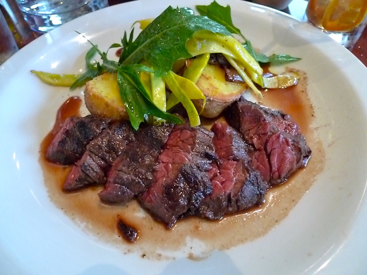 Close up of a plate of grilled steak with salad at Nopa, a popular San Francisco restaurant