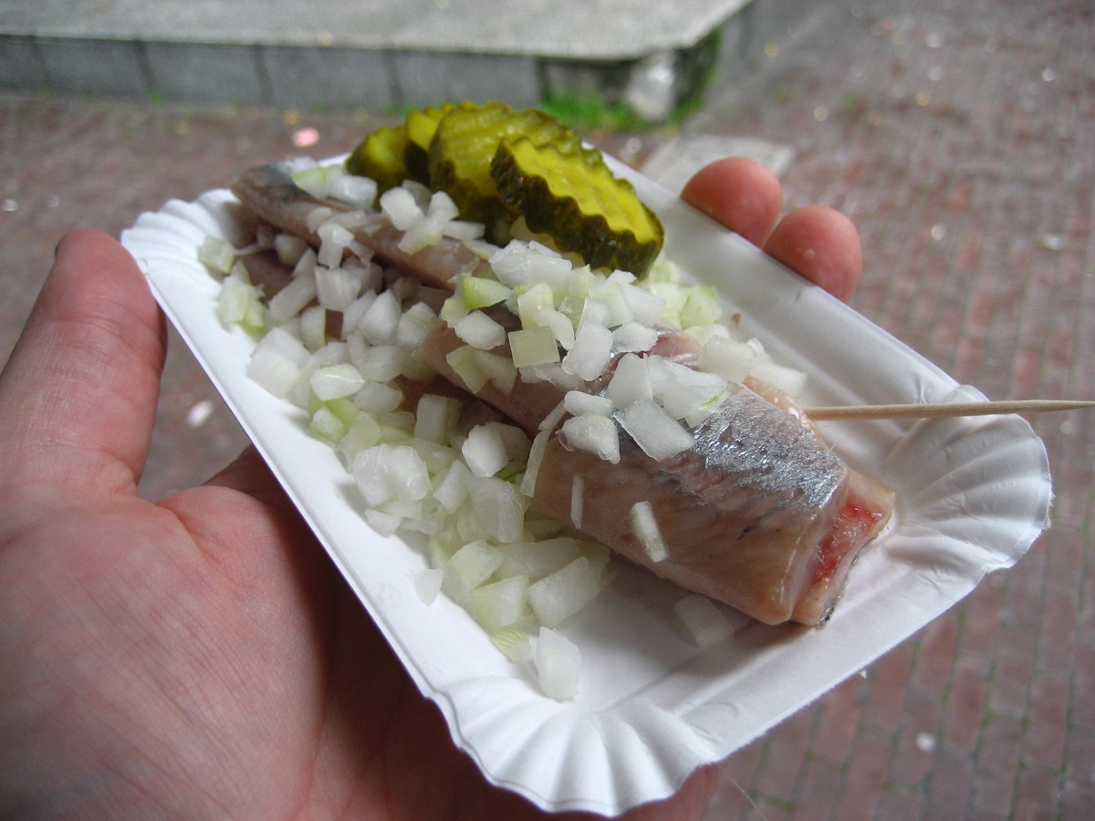 Herring with pickles and onions on a tray to eat on the street in Amsterdam
