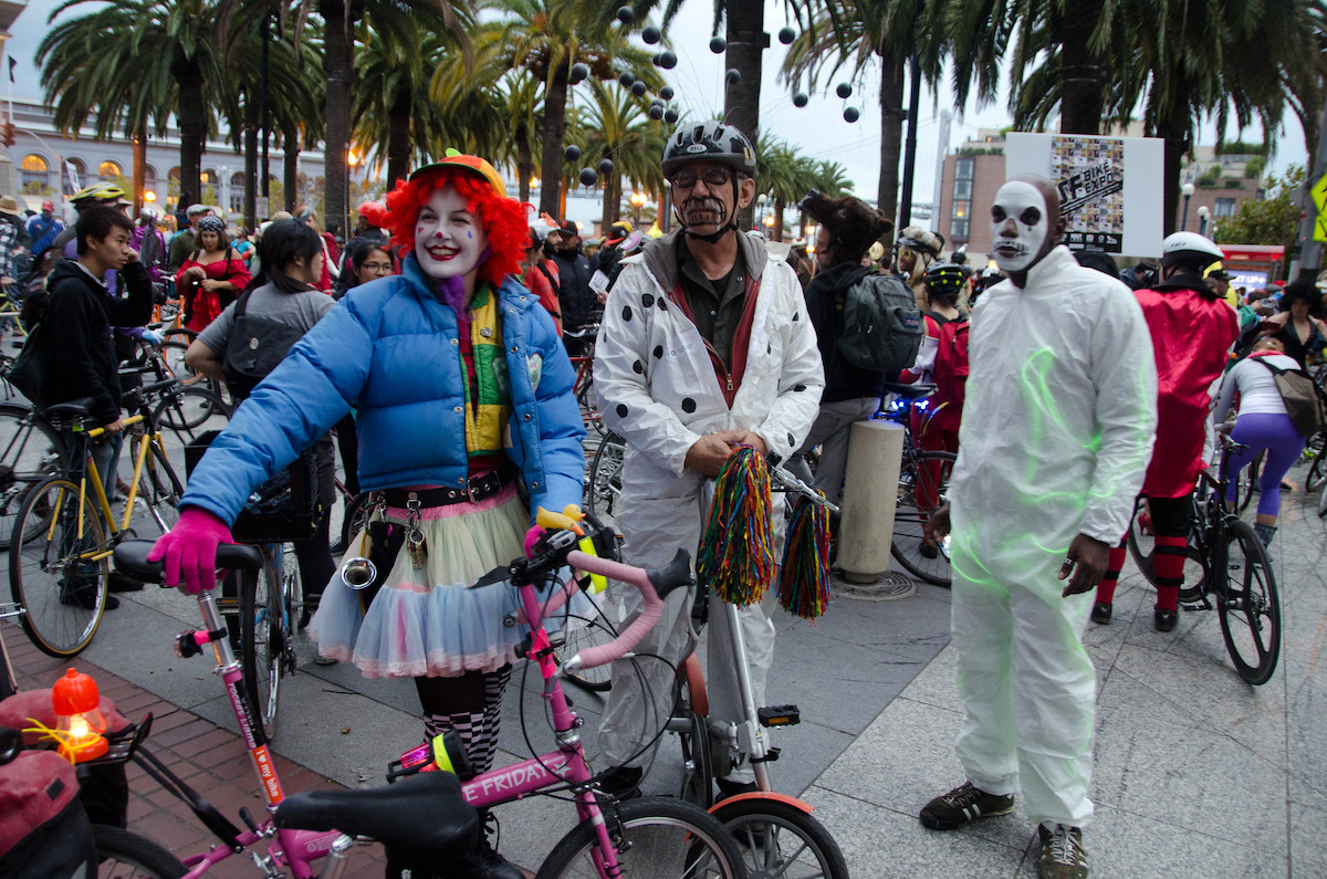 Three people dressed up in Halloween costumes with their bikes at a Critical Mass event in San Francisco