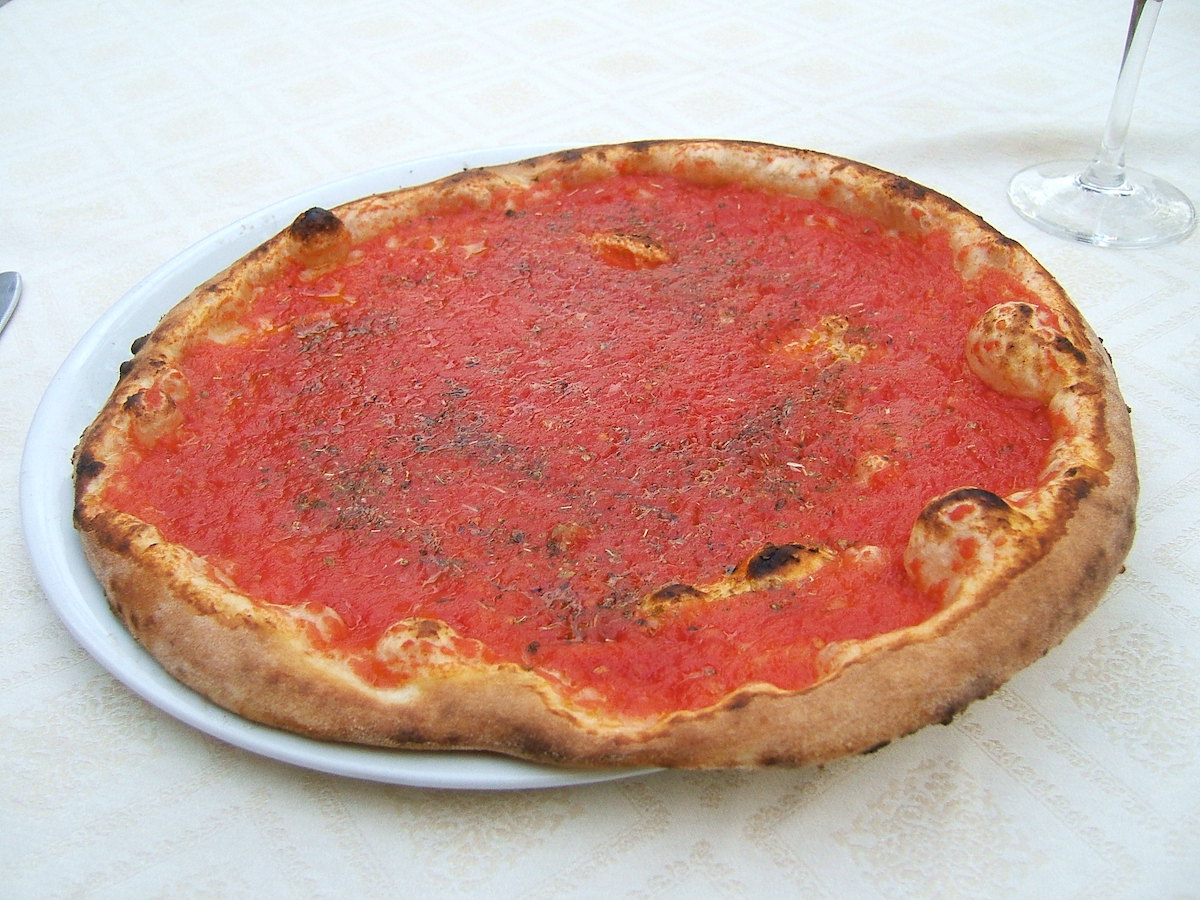 Pizza marinara, a naturally vegan dish found in Naples, is tomato sauce with herbs and garlic atop perfect crust.