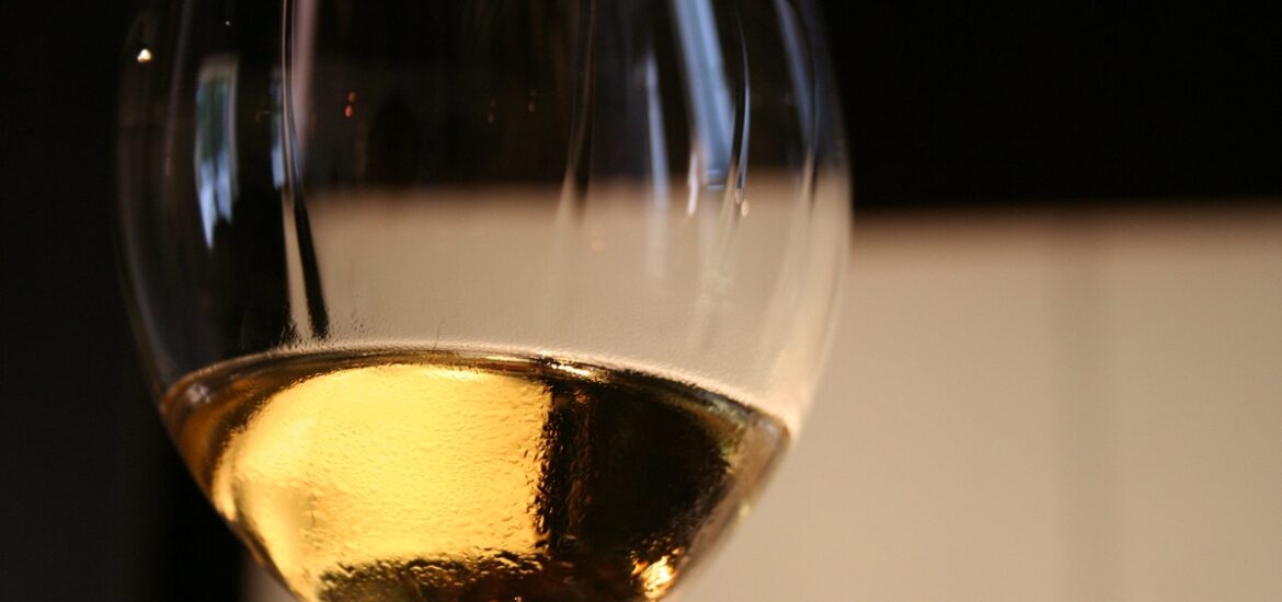 Close up of white Sauternes wine in a glass with wine tears