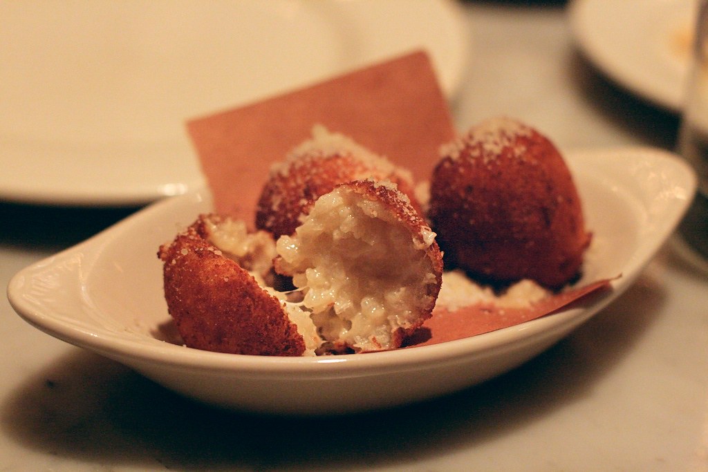 plate of arancini cut in half with cheese and rice