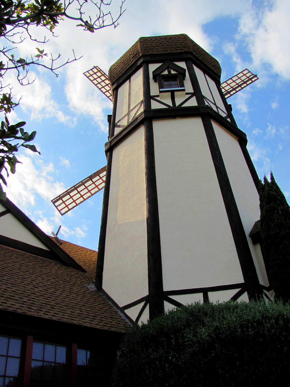 Shot of a Danish style wooden windmill painted white and brown from the ground. The windmill is a Pea Soup Andersen's, a fun pit stop on South Hwy 33 on a Los Angeles to San Francisco road trip