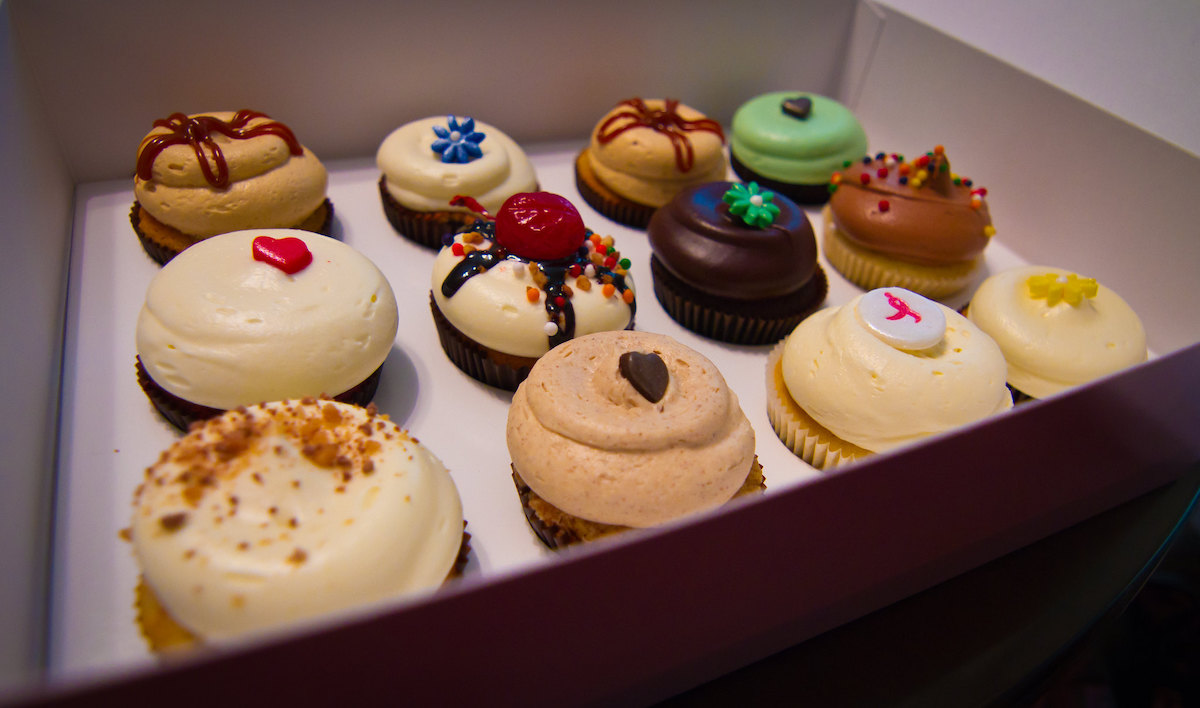 Close up of a box of one dozen cupcakes from Georgetown Cupcakes. All the cupcakes are decorated beautifully and look almost too pretty to eat!