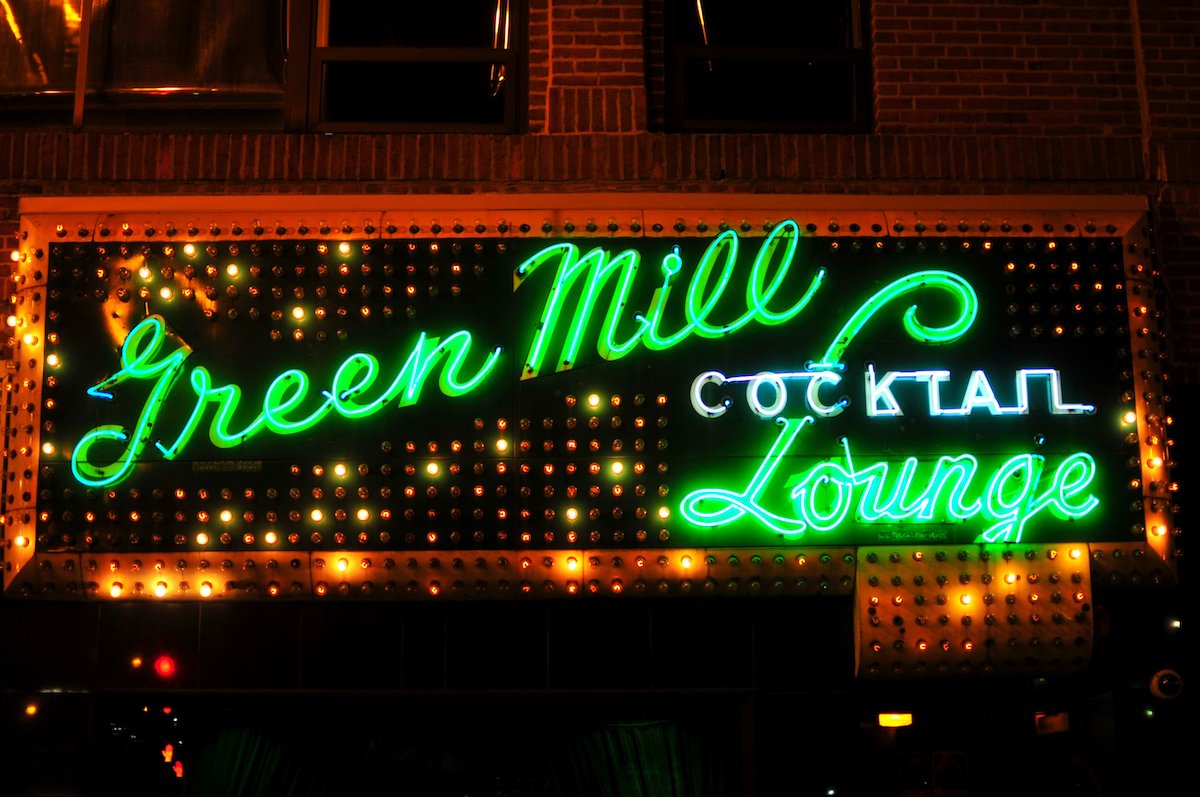 Bright green neon sign that reads Green Mill Cocktail Lounge