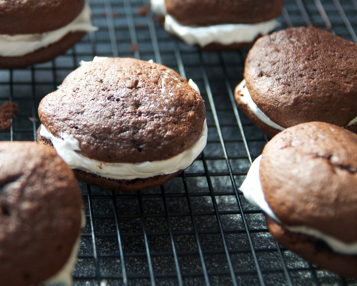 close up of chocolate whoopee pies with white cream in between the two round chocolate cakes