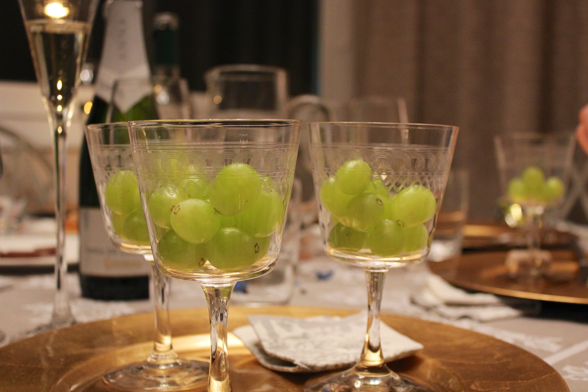 Wine glasses filled with 12 grapes at a place setting with cava in Spain on new year's eve