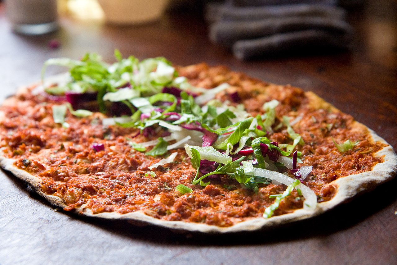 Turkish pizza, or lahmacun, dough spread with a layer of toppings and often served as street food