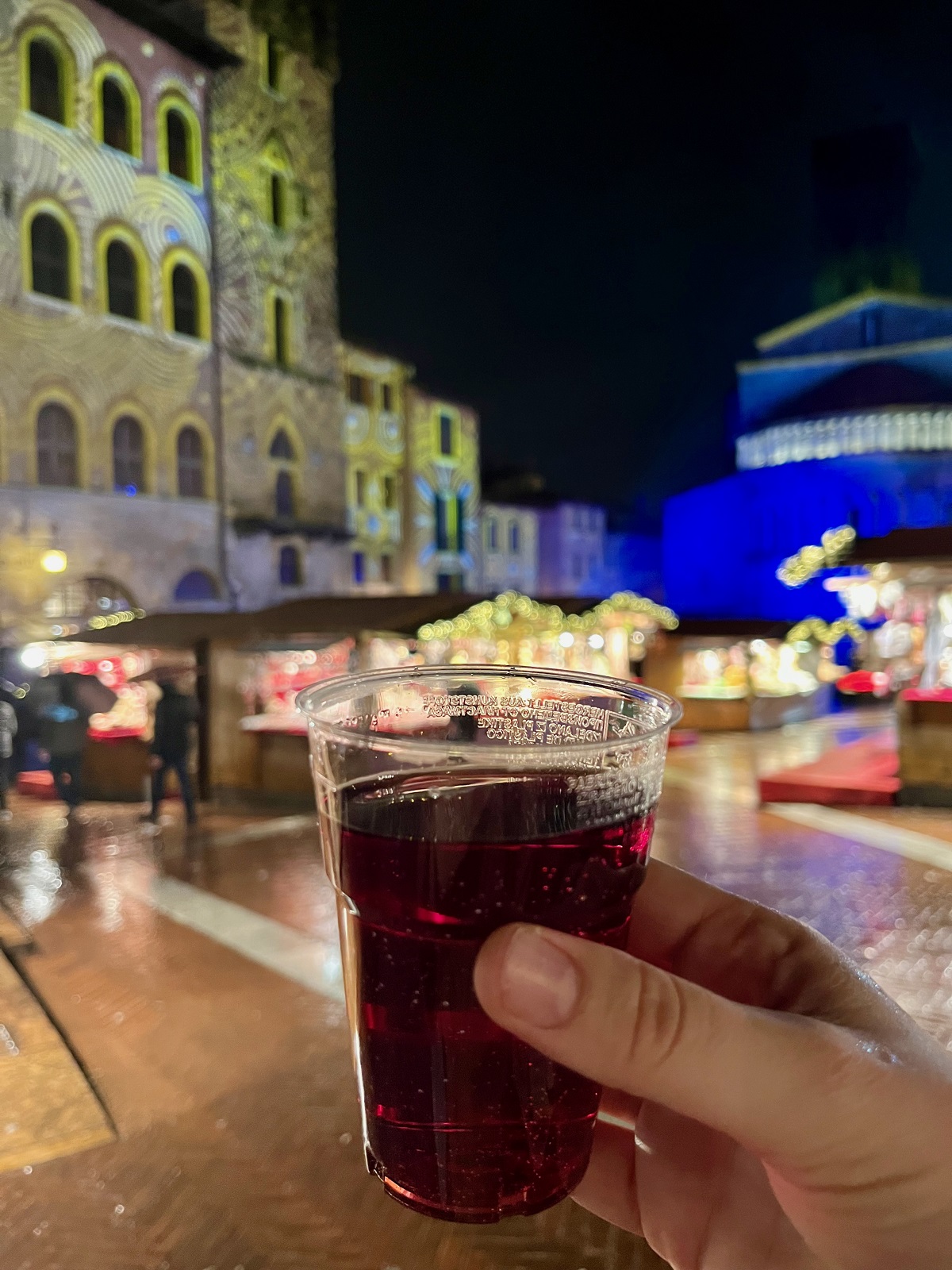 Arezzo Christmas Market in the rain with a glass of wine and lights