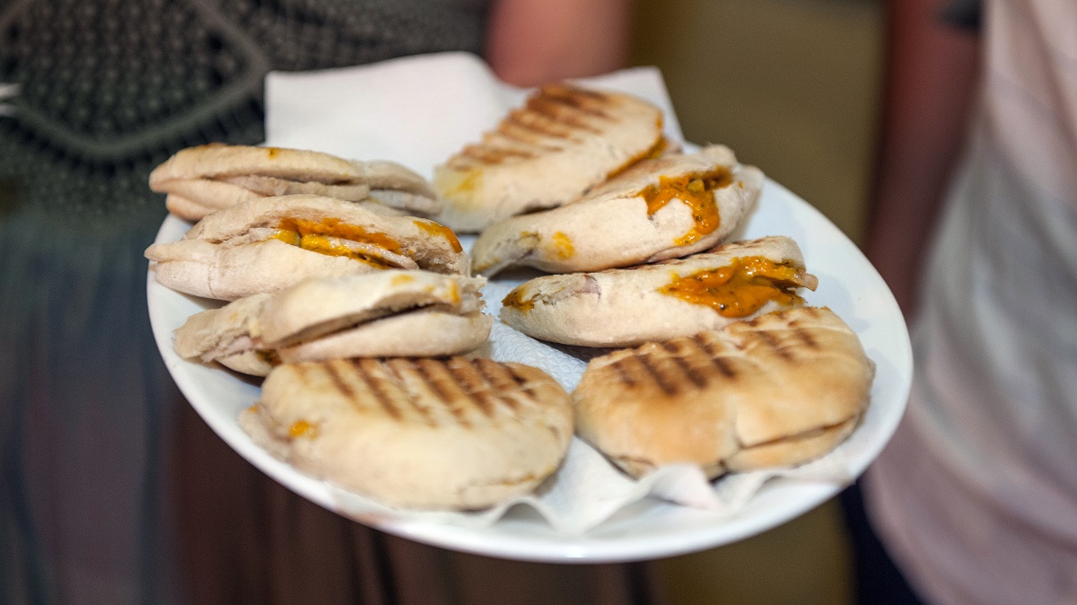 Plate of grilled sandwiches with pork and a red sauce