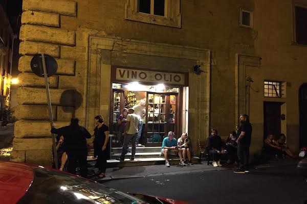 At Il Goccetto, one of Rome's most beloved wine bars, patrons frequently stand outside with a glass of wine
