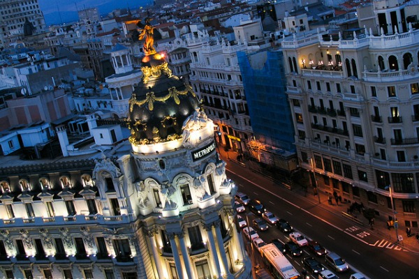 Catching the stunning view of the iconic Metropolis building in Madrid is one of many great date ideas for warm weather in Madrid