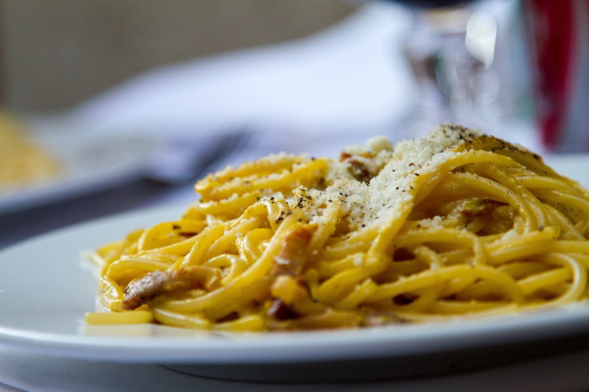plate of carbonara topped with parmesan