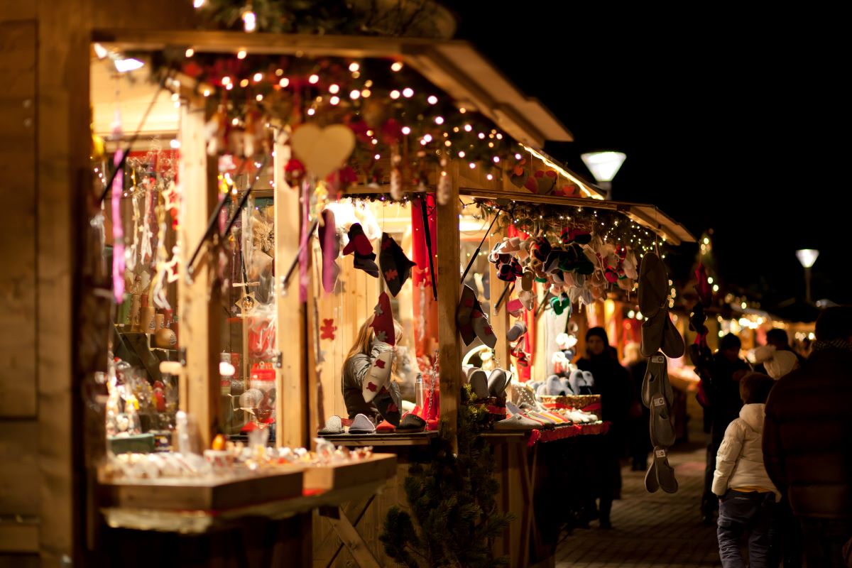 Line of Christmas markets lit up with Christmas lights. 