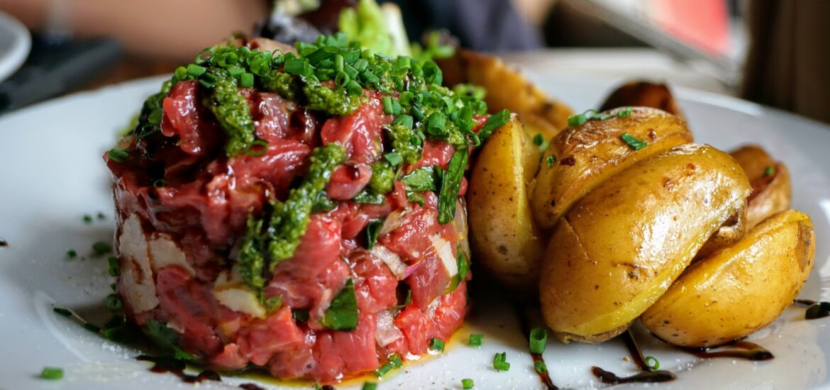 steak tartare with roasted potatoes on a white plate at a fine dining restaurant