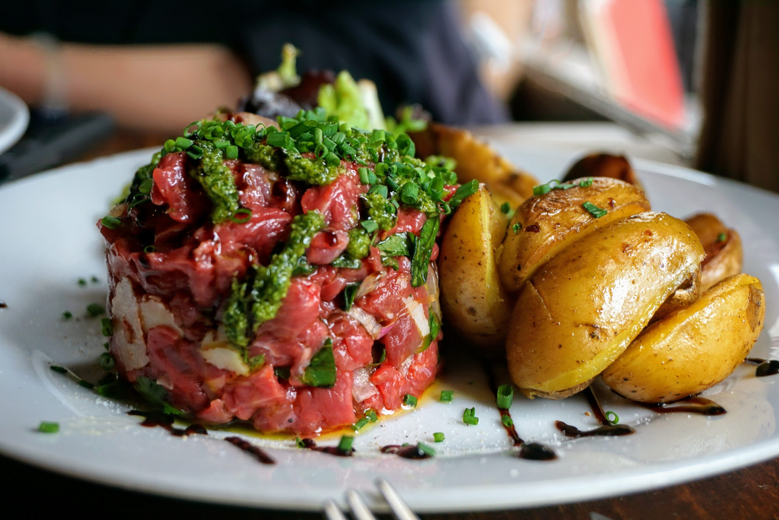 steak tartare with roasted potatoes on a white plate at a fine dining restaurant