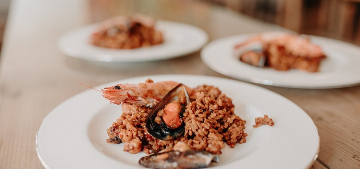 Plate of seafood paella served with a whole shrimp and mussels