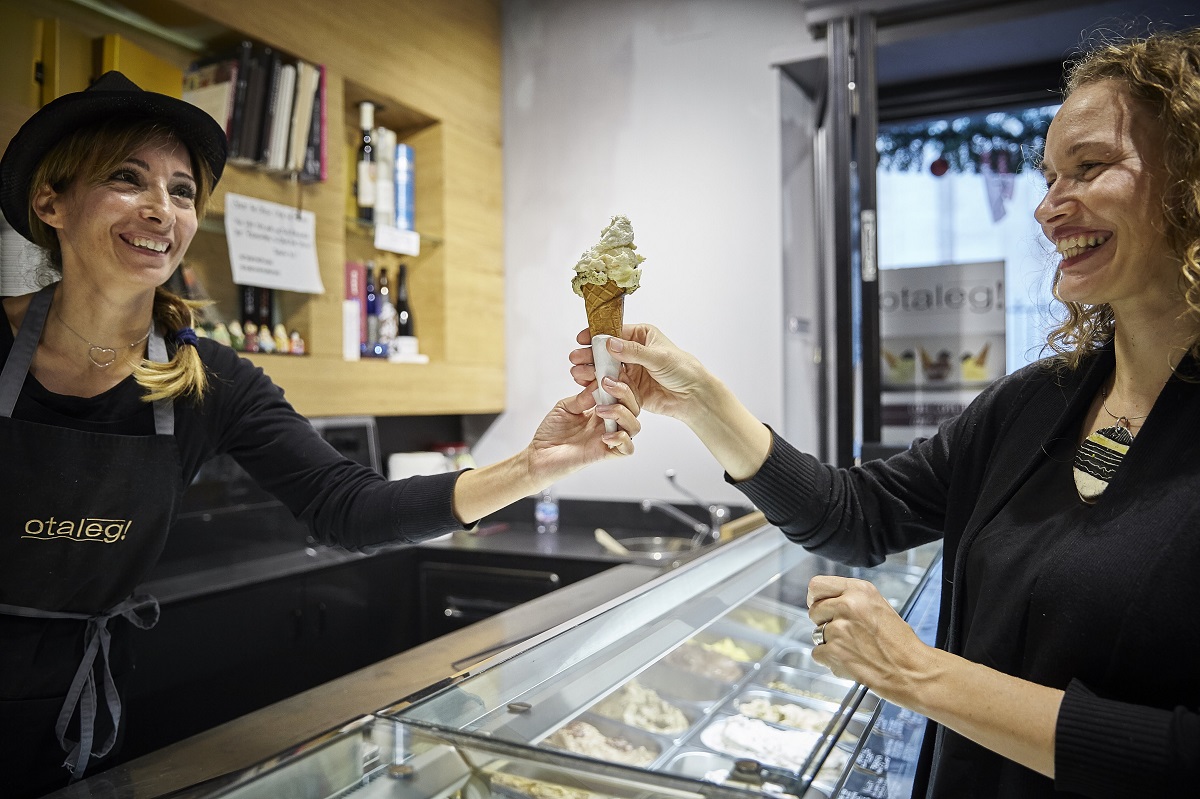 Otaleg gelateria in rome serving an ice cream cone to a smiling customer