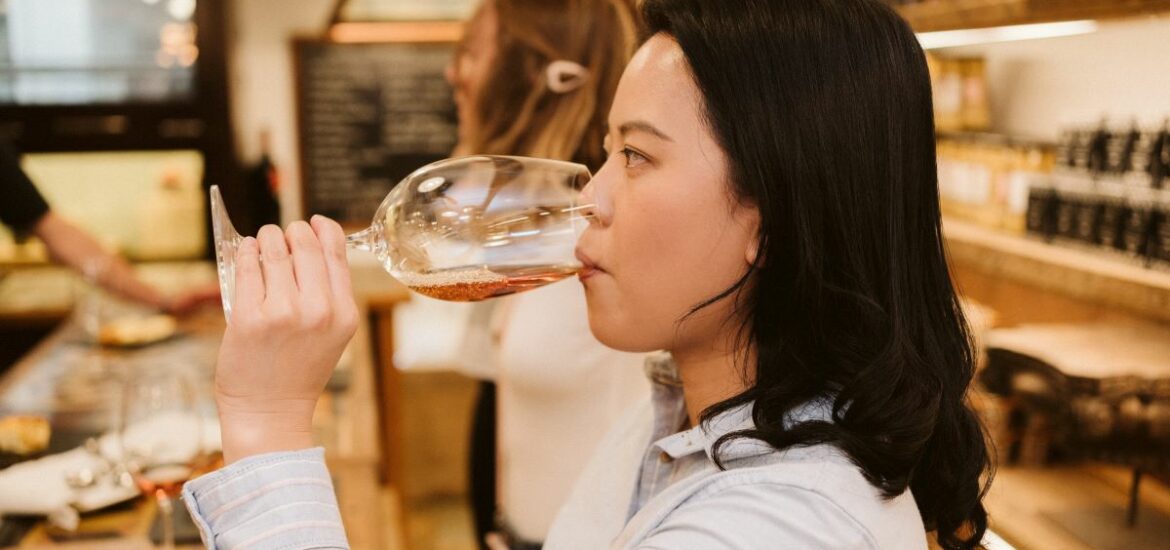 A woman takes a sip of wine
