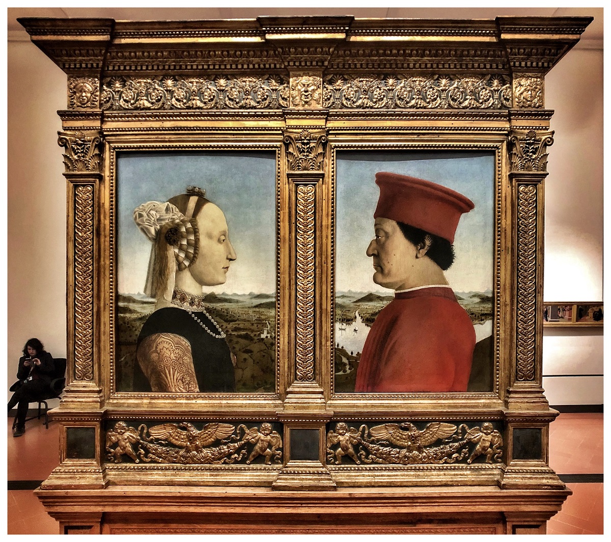 Two mirror portraits of an man and a woman with old dress inside of wooden portrait frames