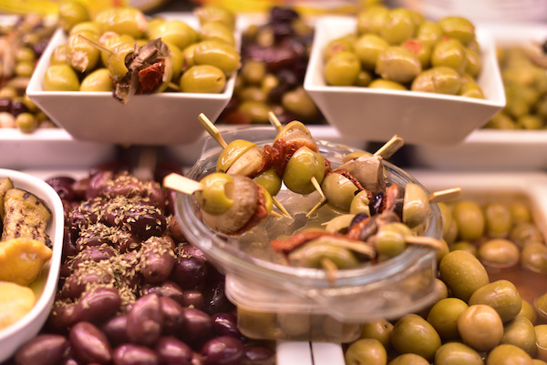 Our food market tours in Barcelona include tastes of traditional products like these yummy olives!