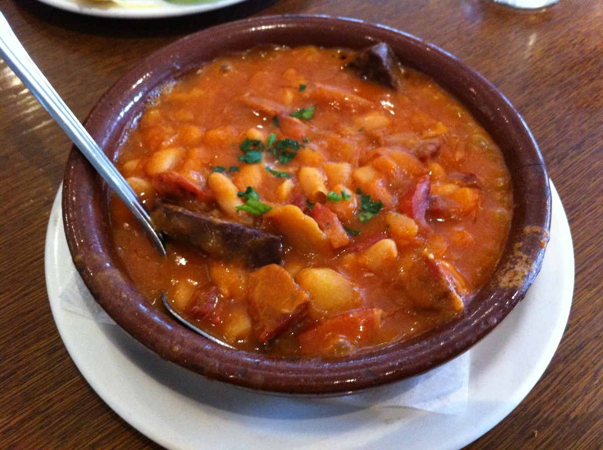 Clay bowl of fabada asturiana (white bean stew with pork)