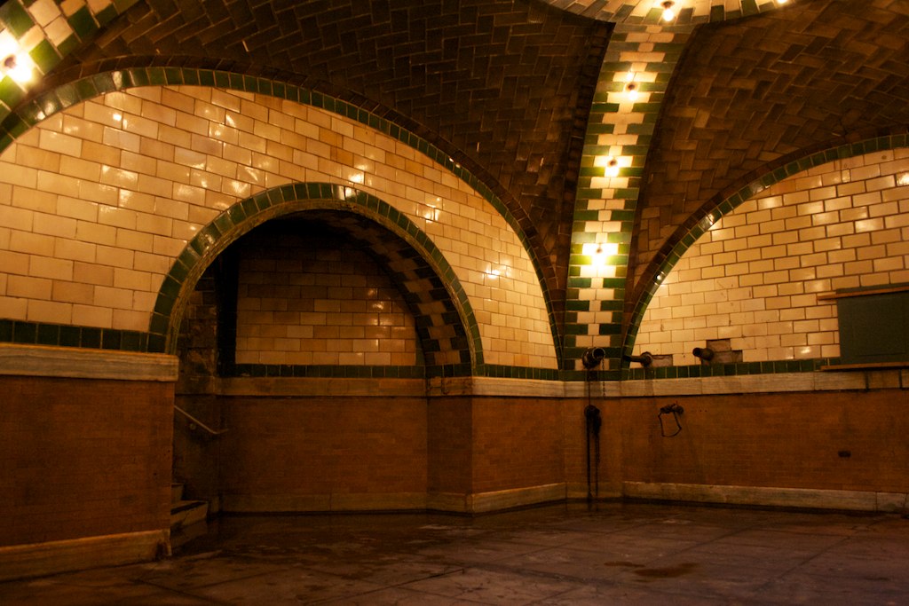A dark, tiled room with dome-shaped entrances on two sides